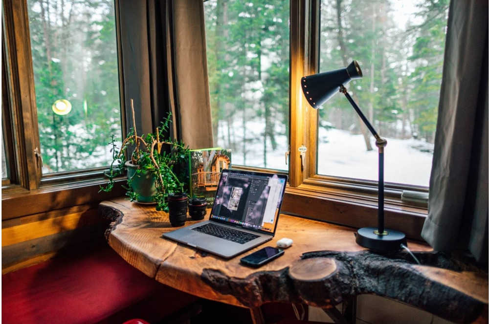 A home office live edge desktop in a corner window